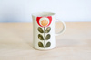 Kubek na kawę. Biały z czerwono-zielonym kwiatem