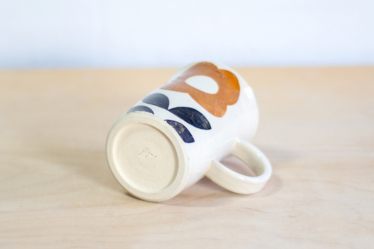 Kubek na kawę. Biały z kwiatem w kolorze ochry