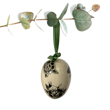 Jajko wielkanocne z zieloną wstążeczką. Kwiaty z tatuaży czarne