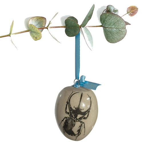 Jajko wielkanocne z błękitną wstążeczką. Żuk i ćma