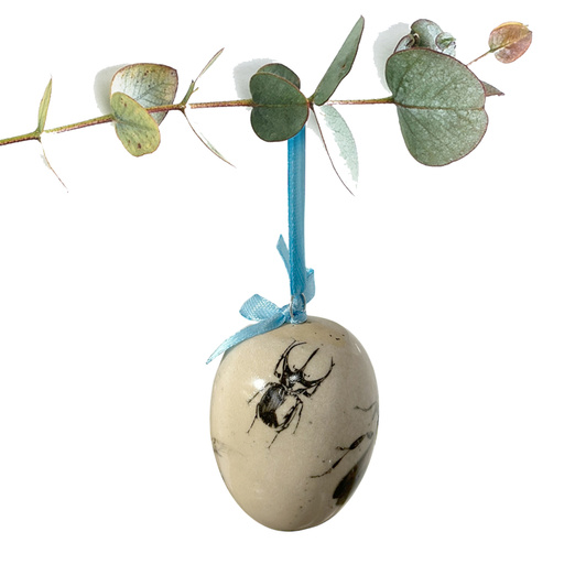 Jajko wielkanocne z błękitną wstążeczką. Żuczki