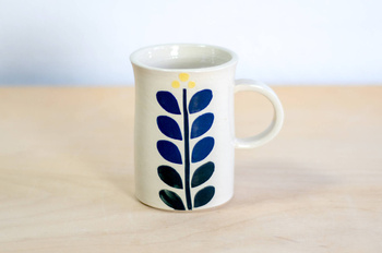 Kubek na kawę. Biały z granatowo-żółtym kwiatem
