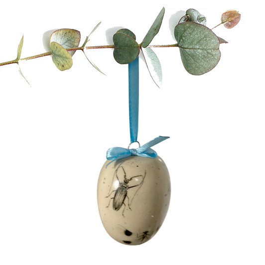 Jajko wielkanocne z błękitną wstążeczką. Biały kwiatek i owady