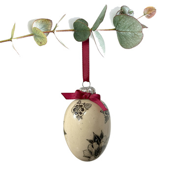 Jajko wielkanocne z bordową wstążeczką. Kwiaty z tatuaży w jasnych odcieniach