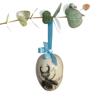 Jajko wielkanocne z błękitną wstążeczką. Żuczki